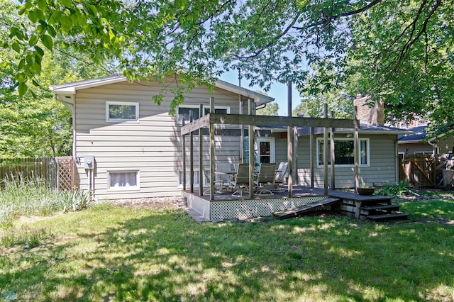 rear view of property with a deck and a lawn