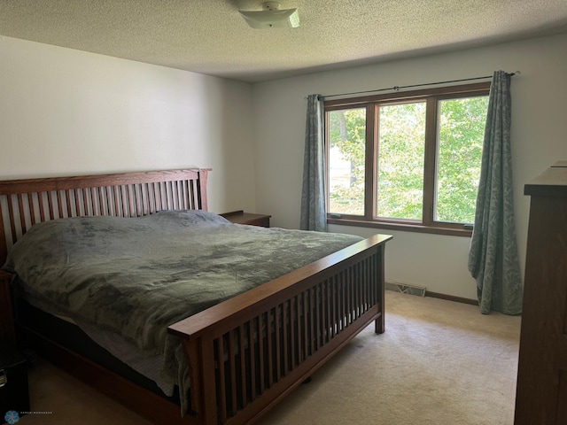 carpeted bedroom featuring a textured ceiling