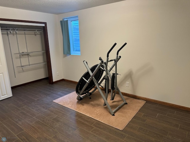 workout room with a textured ceiling and dark hardwood / wood-style flooring