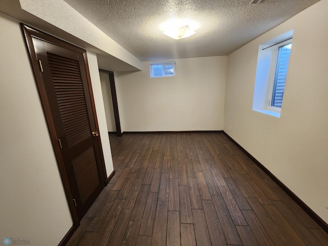 interior space with a textured ceiling and dark hardwood / wood-style flooring