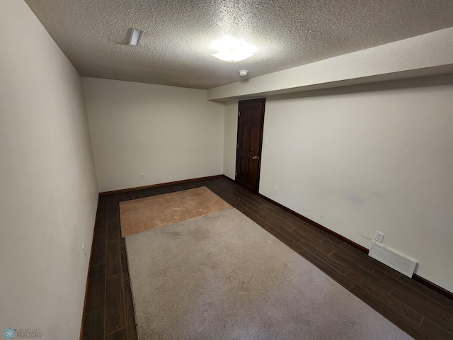 unfurnished room with dark hardwood / wood-style floors and a textured ceiling