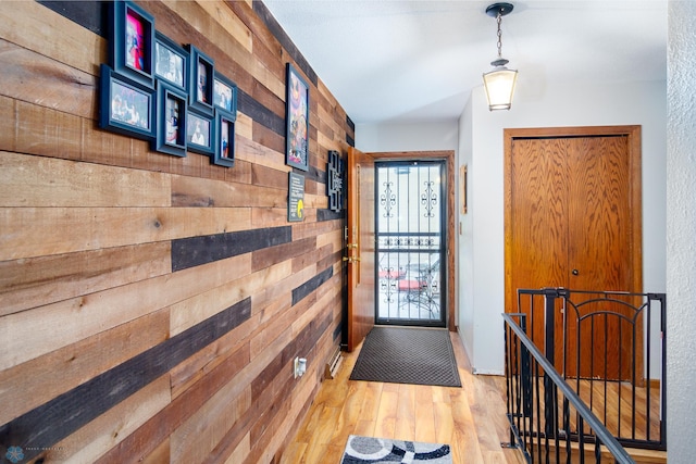 doorway featuring wood walls and light wood-type flooring