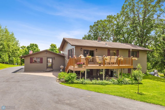 view of front of home with a deck and a front yard