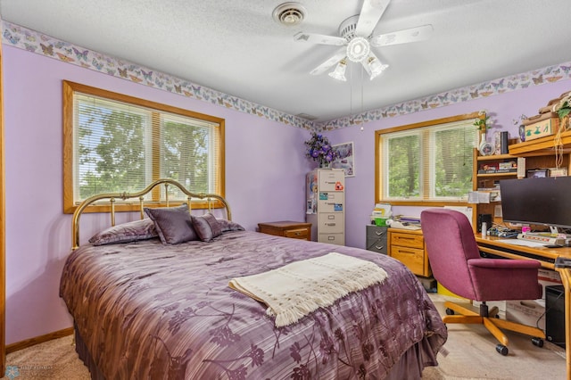 bedroom featuring light carpet, a textured ceiling, multiple windows, and ceiling fan