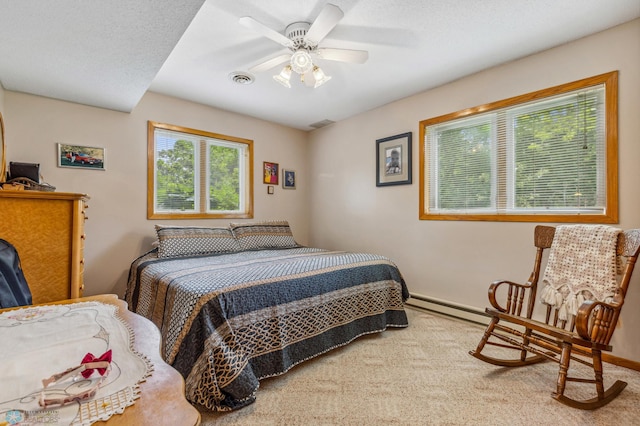 carpeted bedroom with a baseboard heating unit and ceiling fan