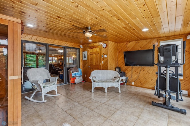 living room featuring tile patterned floors, wooden ceiling, wood walls, and ceiling fan