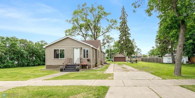 view of front facade featuring a garage, an outbuilding, and a front lawn