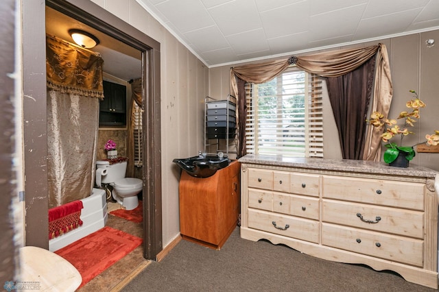 carpeted bedroom featuring crown molding and connected bathroom