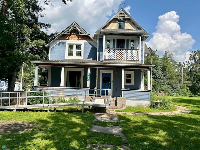 view of front of property with a porch, a balcony, and a front yard