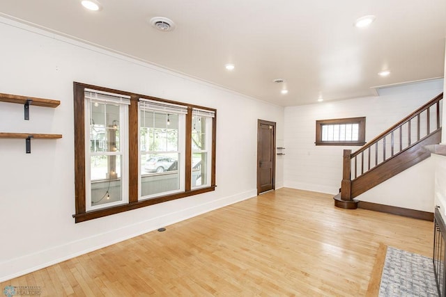 foyer entrance with light wood-type flooring and ornamental molding