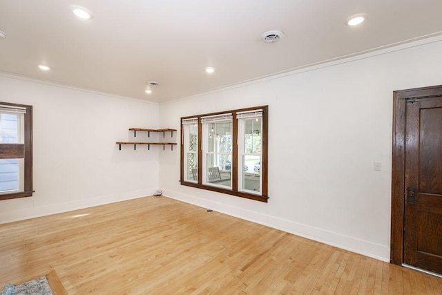 spare room featuring light wood-type flooring and ornamental molding