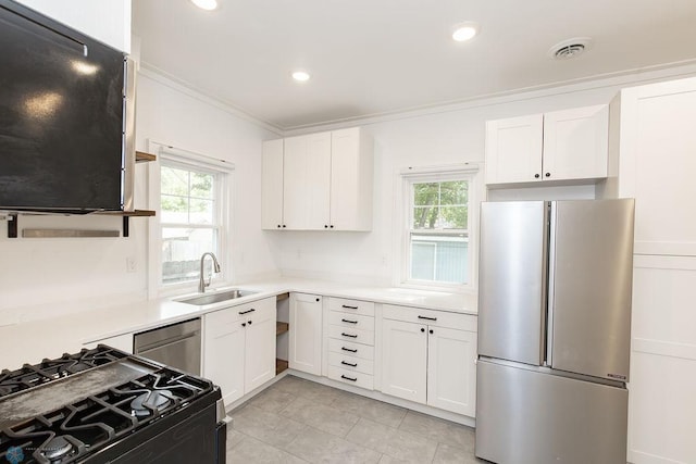 kitchen featuring white cabinetry, a healthy amount of sunlight, appliances with stainless steel finishes, and sink