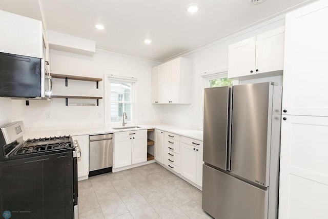 kitchen with light tile patterned floors, a healthy amount of sunlight, appliances with stainless steel finishes, and sink