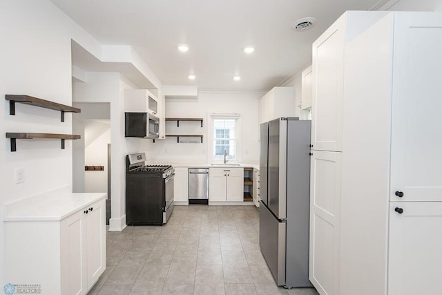 kitchen featuring sink, white cabinetry, light tile patterned flooring, and stainless steel appliances