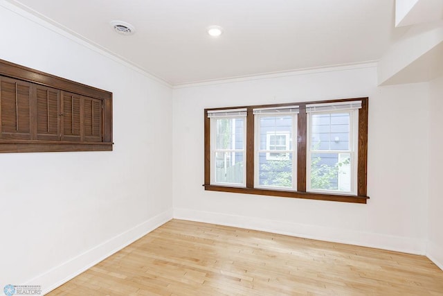 unfurnished room with light hardwood / wood-style floors and crown molding