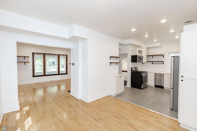 kitchen featuring white cabinetry, stainless steel appliances, and light hardwood / wood-style floors