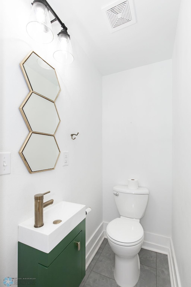 bathroom featuring vanity, tile patterned flooring, and toilet