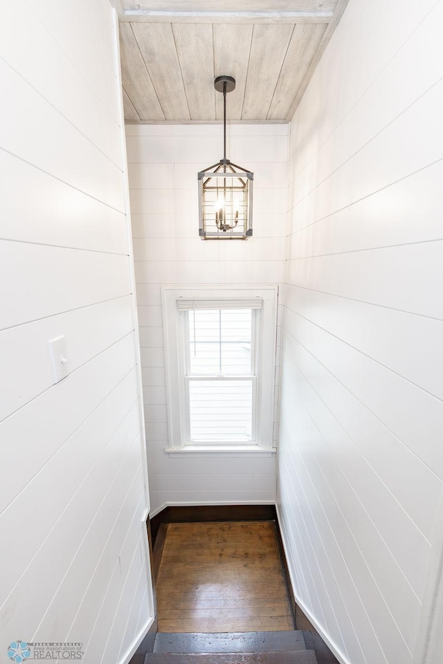 staircase with dark hardwood / wood-style flooring and a chandelier