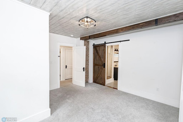 unfurnished bedroom with brick wall, carpet flooring, and a barn door