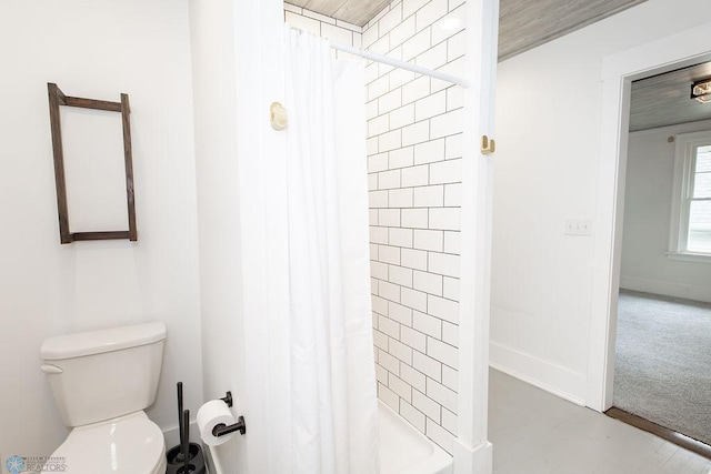 bathroom featuring curtained shower, toilet, and wooden ceiling