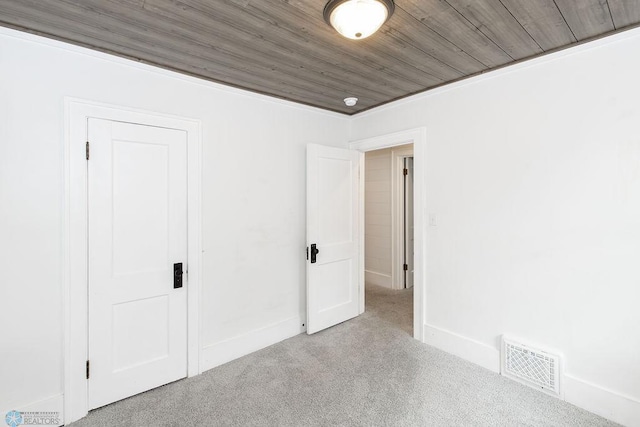 spare room with carpet flooring and wood ceiling