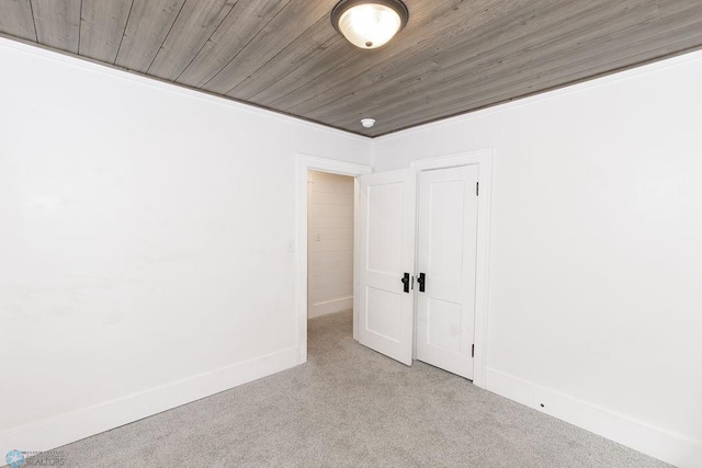 carpeted empty room featuring wooden ceiling