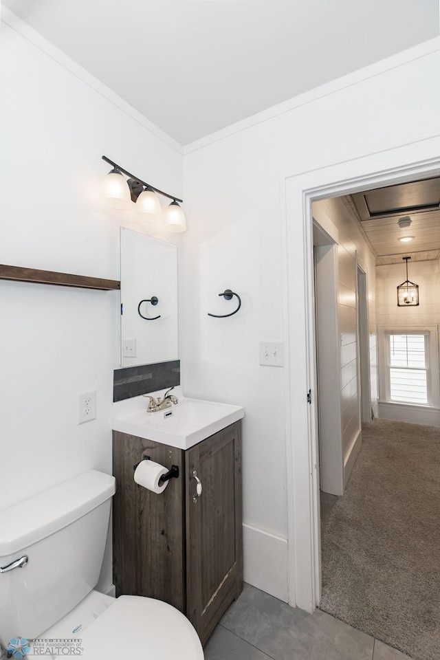 bathroom featuring vanity, crown molding, tile patterned flooring, and toilet