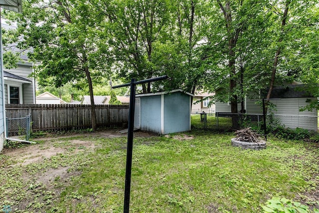 view of yard featuring a storage unit and an outdoor fire pit