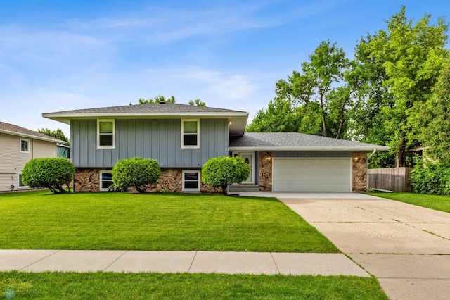 tri-level home featuring a garage and a front yard