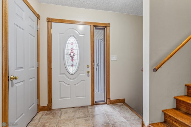 tiled entrance foyer with a textured ceiling