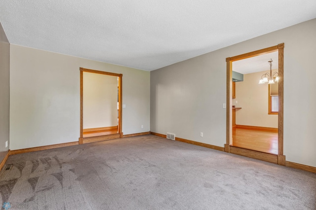 unfurnished bedroom featuring a chandelier, carpet, and connected bathroom