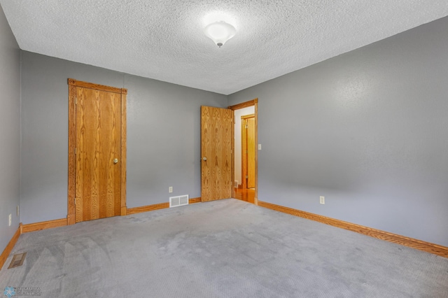 unfurnished bedroom featuring carpet and a textured ceiling