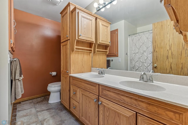 bathroom with dual vanity, tile patterned floors, and toilet