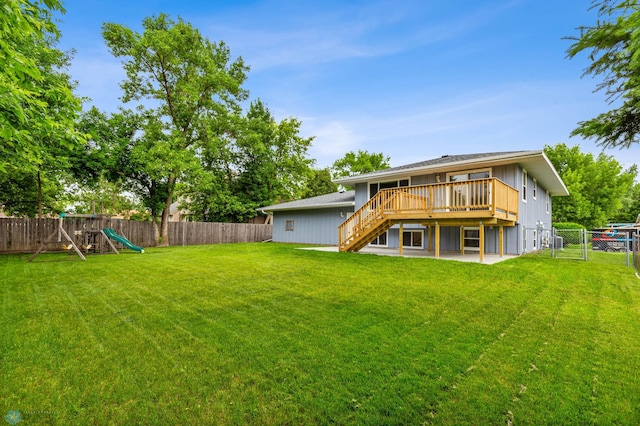 back of house with a playground, a yard, a patio area, and a deck