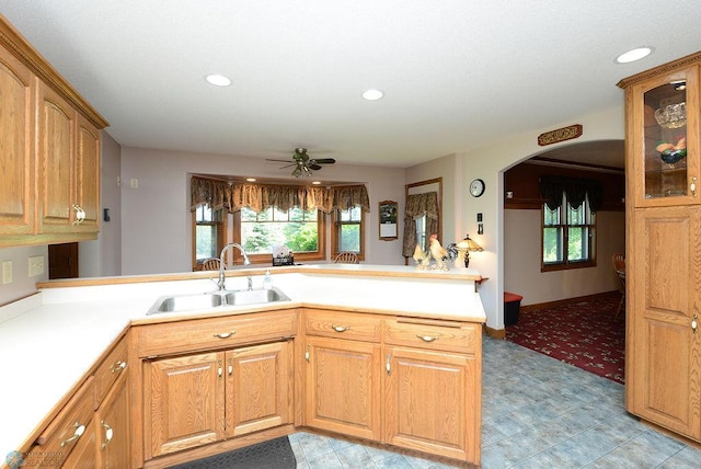 kitchen with kitchen peninsula, sink, light tile patterned floors, and ceiling fan