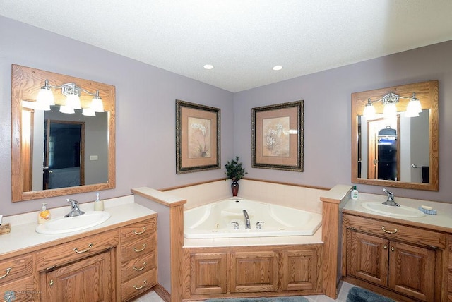 bathroom featuring a tub to relax in, a textured ceiling, and double sink vanity