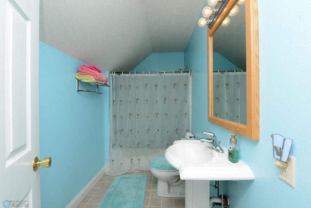 bathroom with toilet, a textured ceiling, lofted ceiling, and tile patterned floors