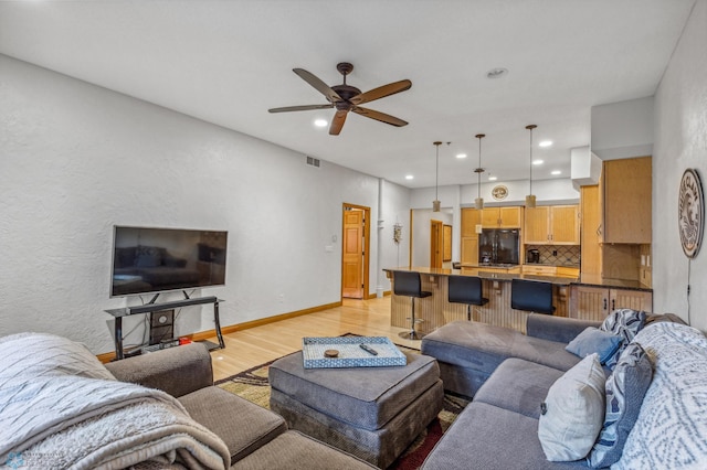 living room with light wood-type flooring and ceiling fan