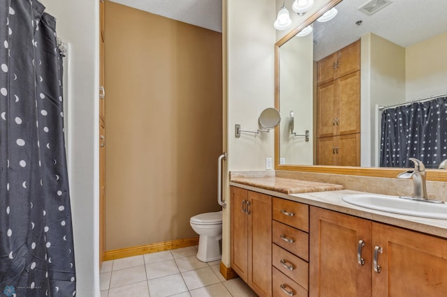 bathroom with dual vanity, toilet, a textured ceiling, and tile patterned flooring