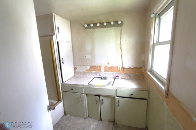 kitchen featuring sink, a wealth of natural light, and light tile patterned floors