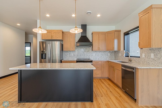 kitchen with appliances with stainless steel finishes, tasteful backsplash, wall chimney range hood, light hardwood / wood-style floors, and a center island