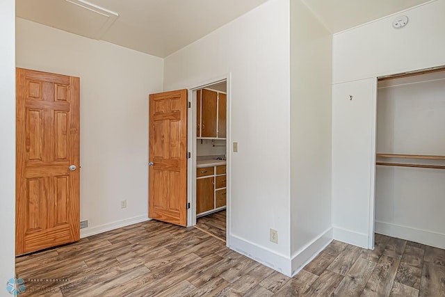 unfurnished bedroom featuring hardwood / wood-style flooring and a closet