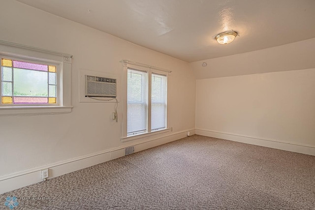 spare room featuring carpet and a wall mounted air conditioner