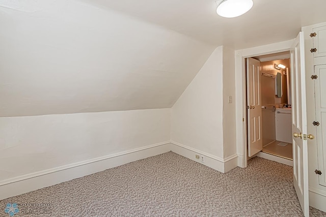 additional living space featuring vaulted ceiling and carpet flooring