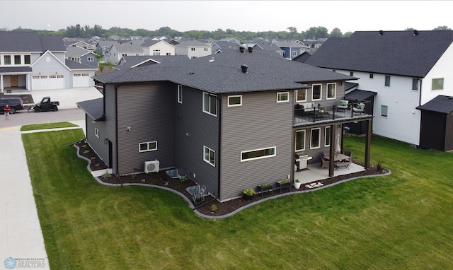 rear view of property with a patio, a garage, central AC unit, a balcony, and a lawn