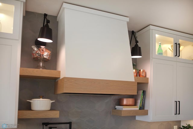 interior space featuring decorative backsplash and white cabinets