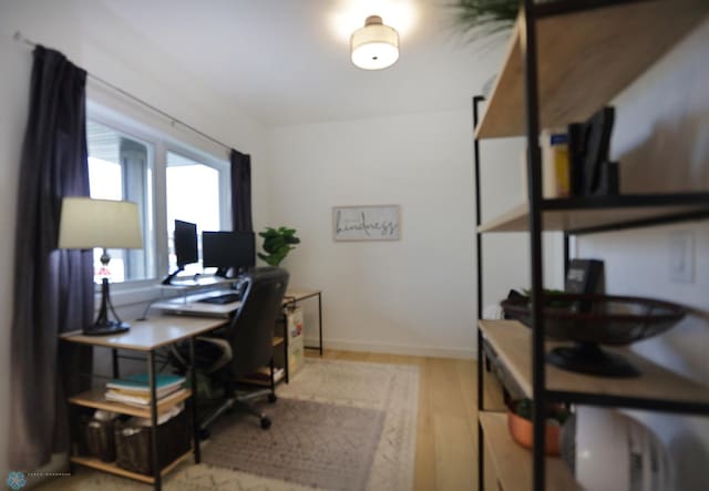 home office with light hardwood / wood-style floors