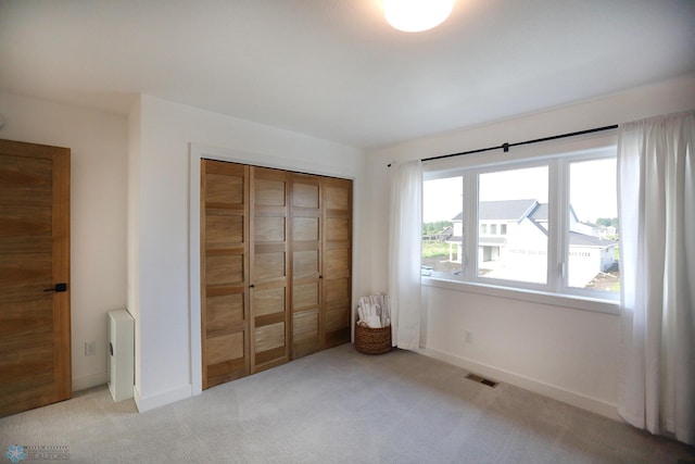 unfurnished bedroom with a closet and carpet flooring