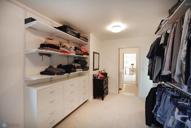 walk in closet featuring light carpet