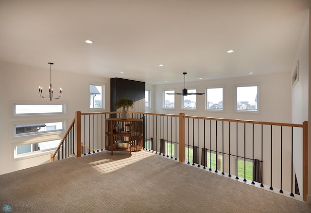 corridor with a notable chandelier, carpet floors, and plenty of natural light